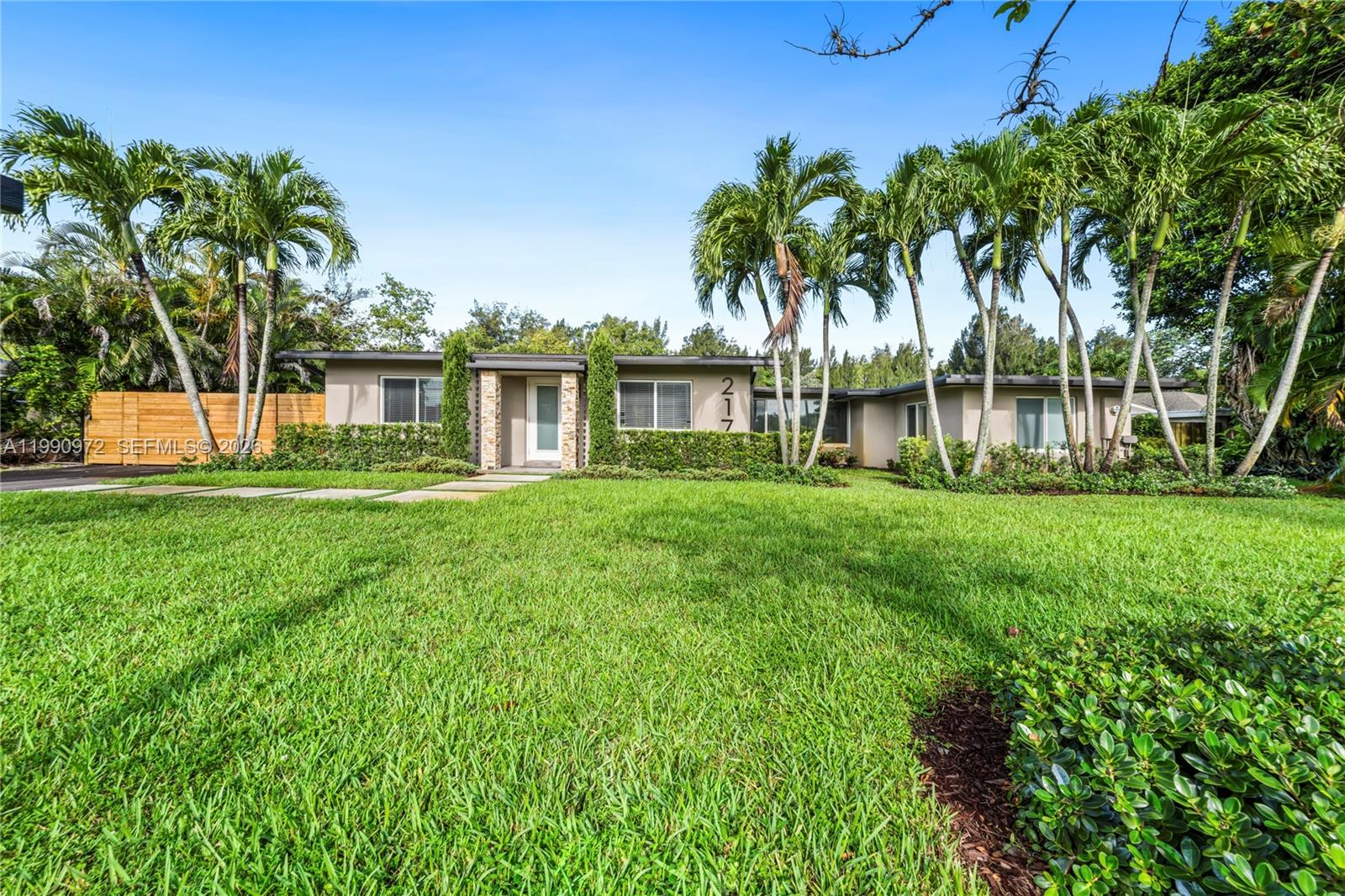 A single-story house with a flat roof, palm trees, and a green lawn — 217 E Acre Dr, Plantation FL 33317, PLANTATION, FL