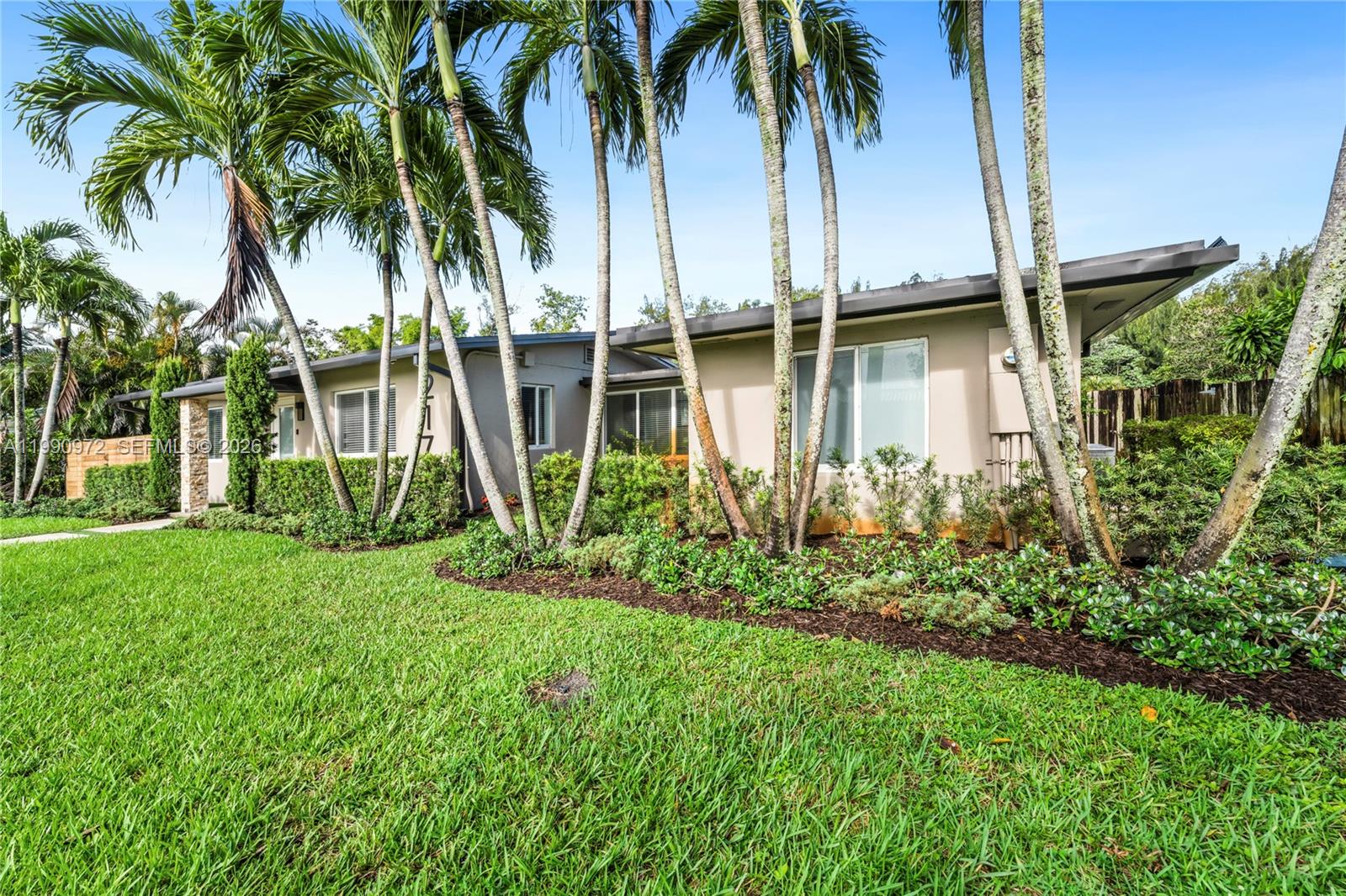 A single-story house with a flat roof is surrounded by palm trees and landscaping — 217 E Acre Dr, Plantation FL 33317, PLANTATION, FL