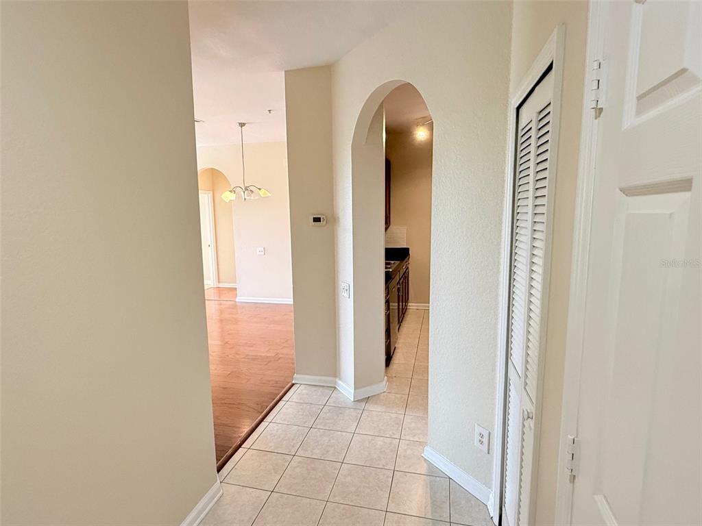 A tiled entryway leads to a kitchen through an archway and a wood-floored living area — 3190 DANTE DRIVE UNIT 301, ORLANDO, FL