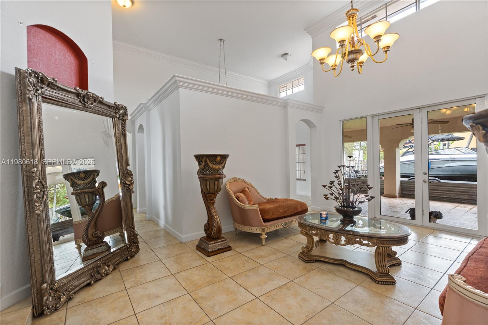A living room features tile floors, a large ornate mirror, and a view of a boat — 12981 SW 197th St, Miami FL 33177, MIAMI, FL