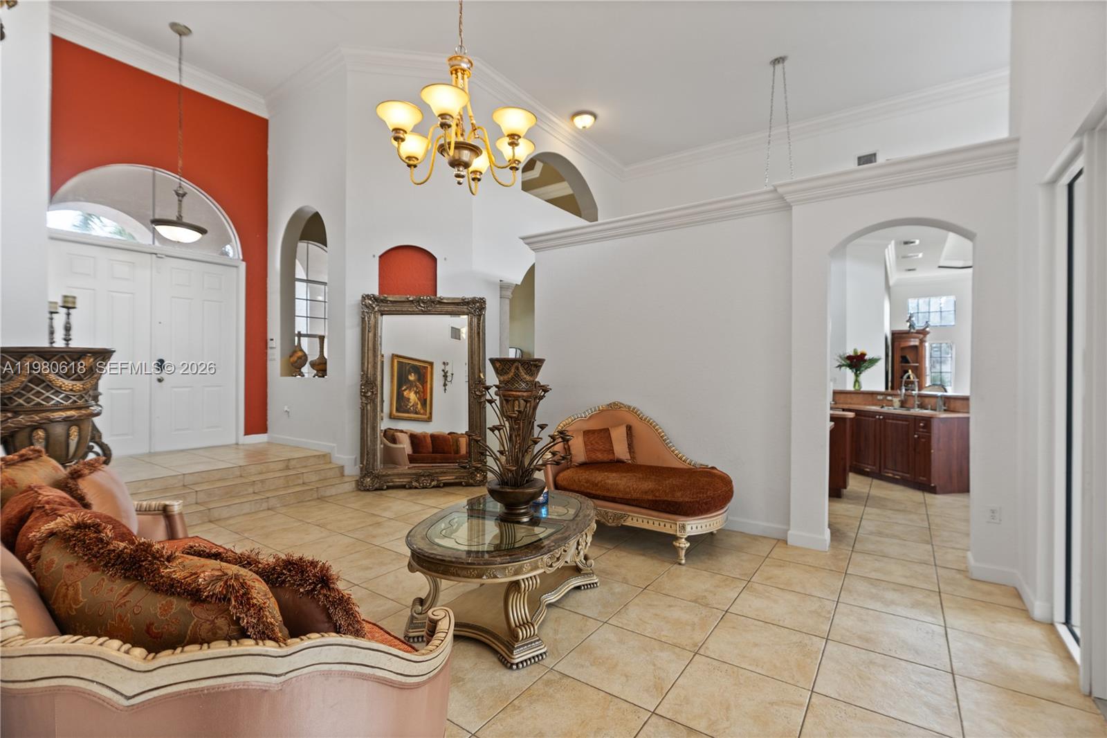A formal living room features tiled floors, a chandelier, a large mirror, and ornate furniture — 12981 SW 197th St, Miami FL 33177, MIAMI, FL