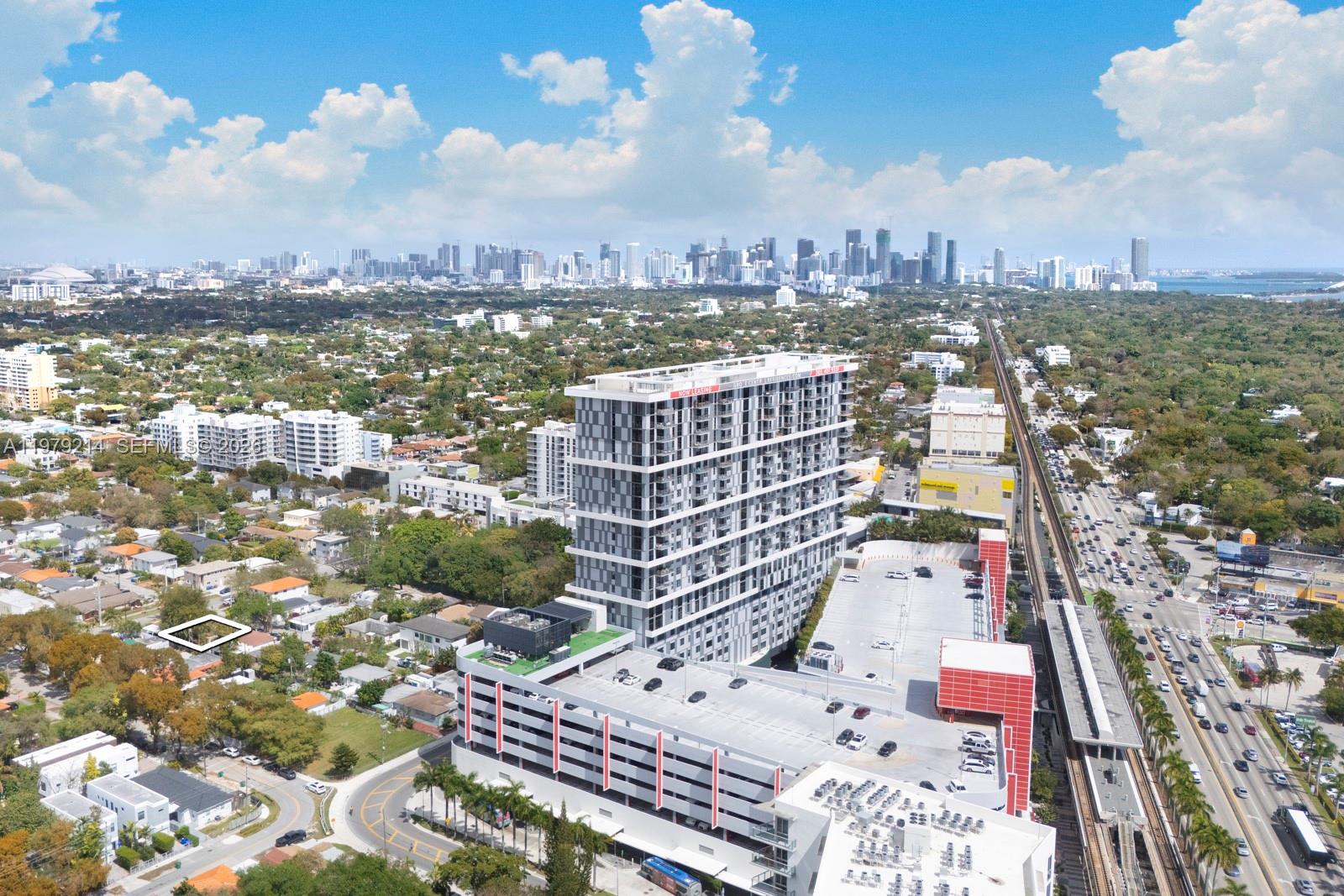 An aerial view shows a modern high-rise apartment building with an attached parking garage — 2710 SW 28th Ct, Miami FL 33133, MIAMI, FL