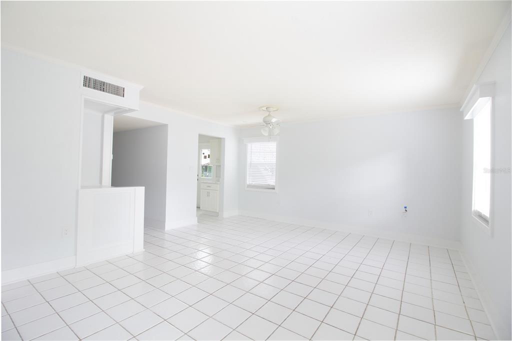An empty room with white walls, white tile flooring, a ceiling fan, and a window — 6960 A SUNSET DRIVE S UNIT 1C, SOUTH PASADENA, FL