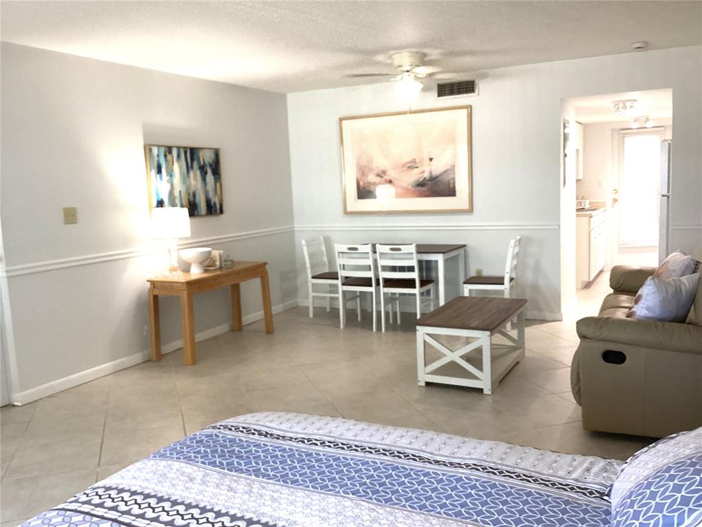 A living and dining area features tile flooring, a ceiling fan, and neutral wall paint — 7701 STARKEY ROAD UNIT 703, SEMINOLE, FL