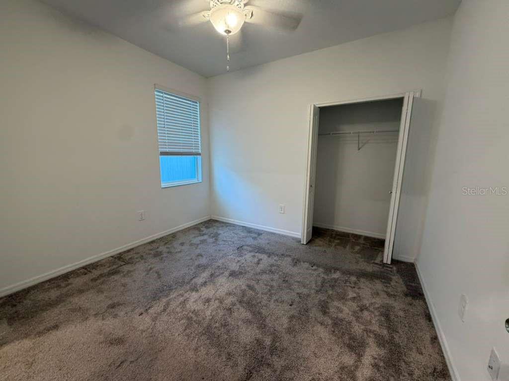 A living room features two light-colored sofas, a beige area rug, and a ceiling fan — 1172 TYLER LOOP, WINTER HAVEN, FL