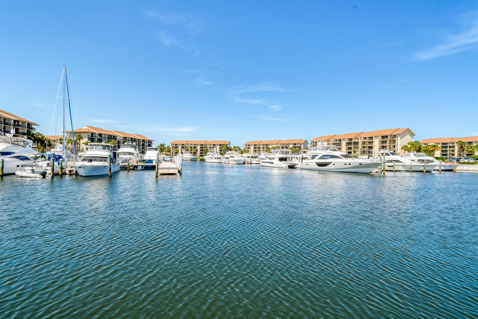 A marina with several docked yachts in front of multi-story residential buildings under a blue sky — 2401 Marina Isle Way # 503, Jupiter FL 33477, JUPITER, FL