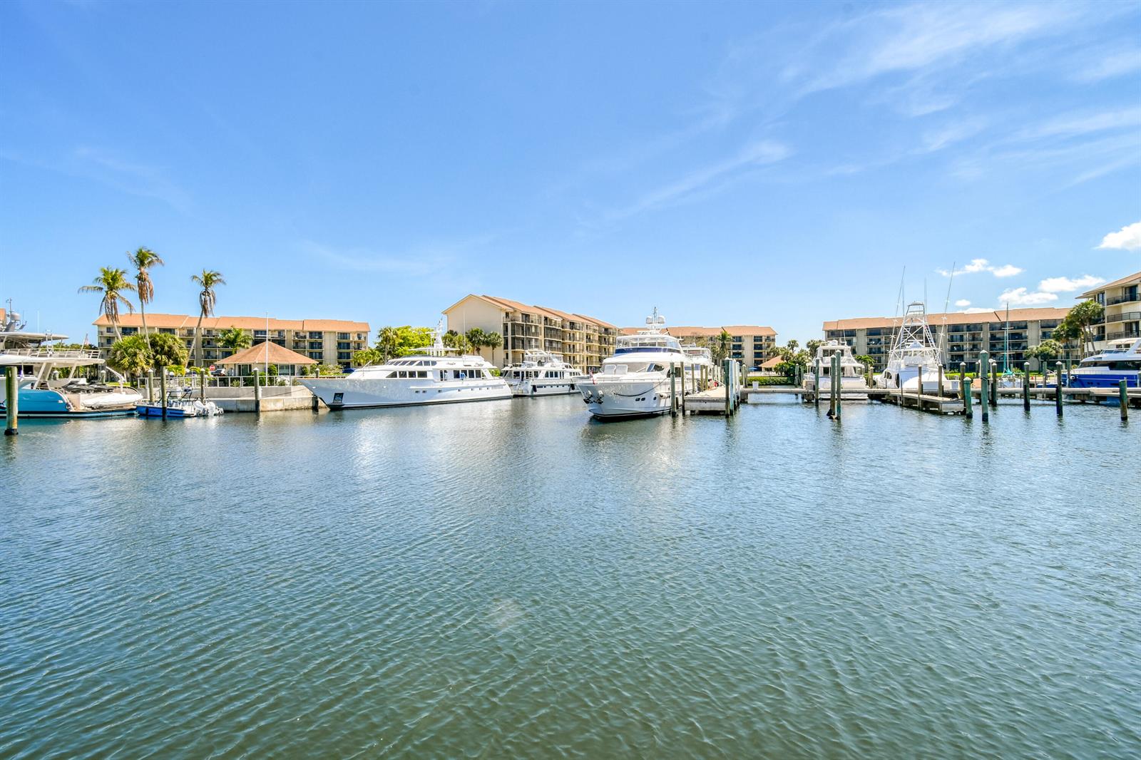 A marina with several yachts docked in front of multi-story residential buildings under a blue sky — 2401 Marina Isle Way # 503, Jupiter FL 33477, JUPITER, FL