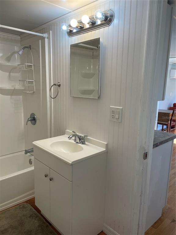 A bathroom features a white vanity, a medicine cabinet, and a shower-tub combination — 6275 - A US HIGHWAY 441 SE, OKEECHOBEE, FL