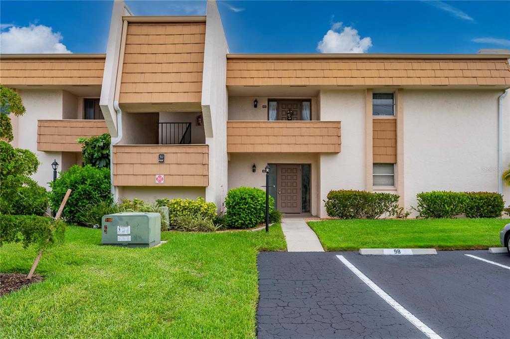 A two-story residential building features tan stucco walls, brown shingle accents, and a parking space — 1080 BAL HARBOR BOULEVARD UNIT 9D, PUNTA GORDA, FL