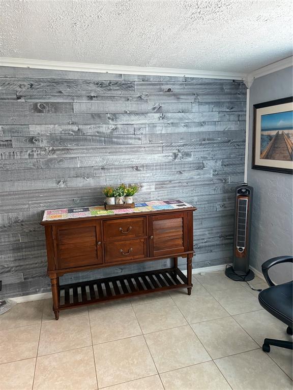 A room features a gray wood-plank accent wall, a wooden sideboard, and tile flooring — 5517 WESTBROOK DRIVE, ORLANDO, FL