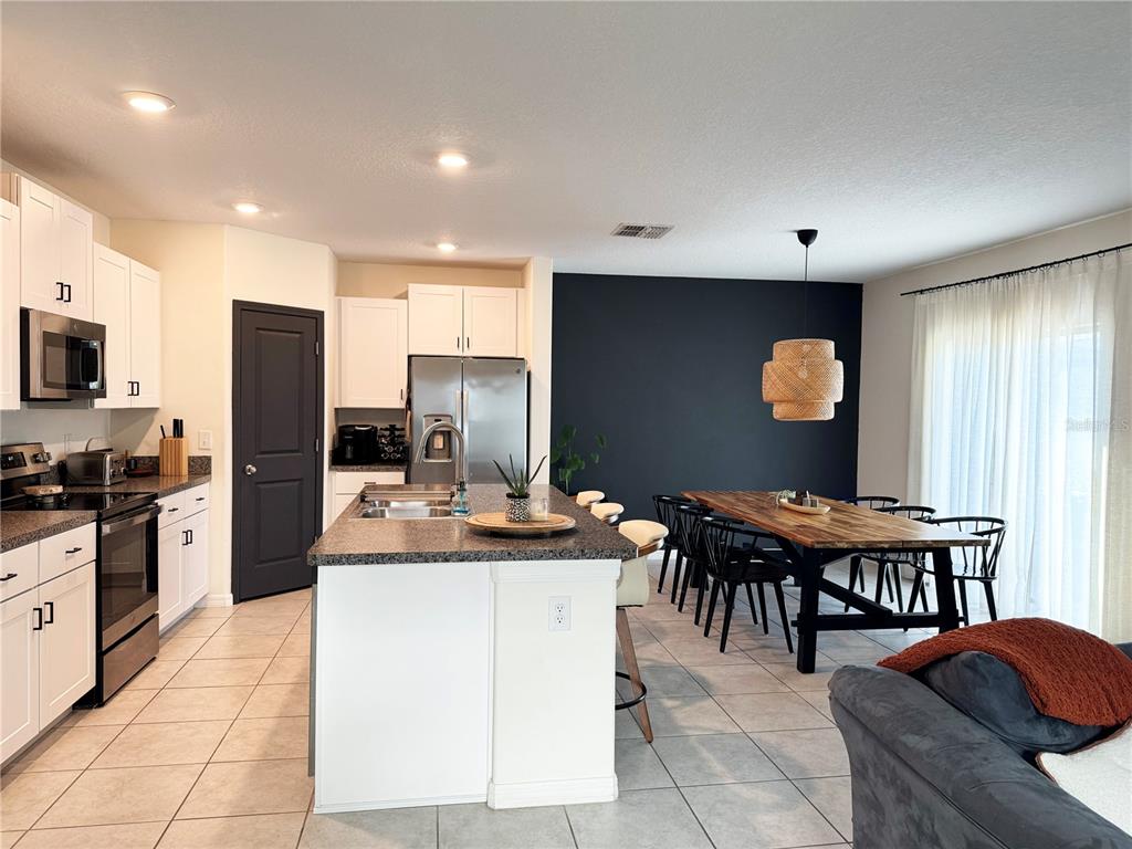 A living room features a large sectional sofa, a beanbag chair, and a wall-mounted television — 6131 SPRING CRAYFISH AVENUE, NEW PORT RICHEY, FL