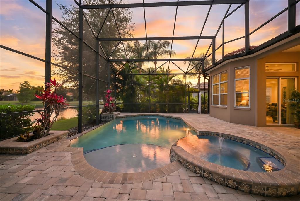 An aerial view of a suburban house with a tile roof, driveway, and backyard pool — 14806 BOWFIN TERRACE, LAKEWOOD RANCH, FL