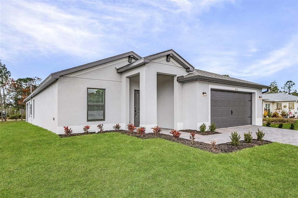 A single-story house with a gray garage, light-colored stucco exterior, and a manicured lawn — 2791 SNUG STREET, NORTH PORT, FL
