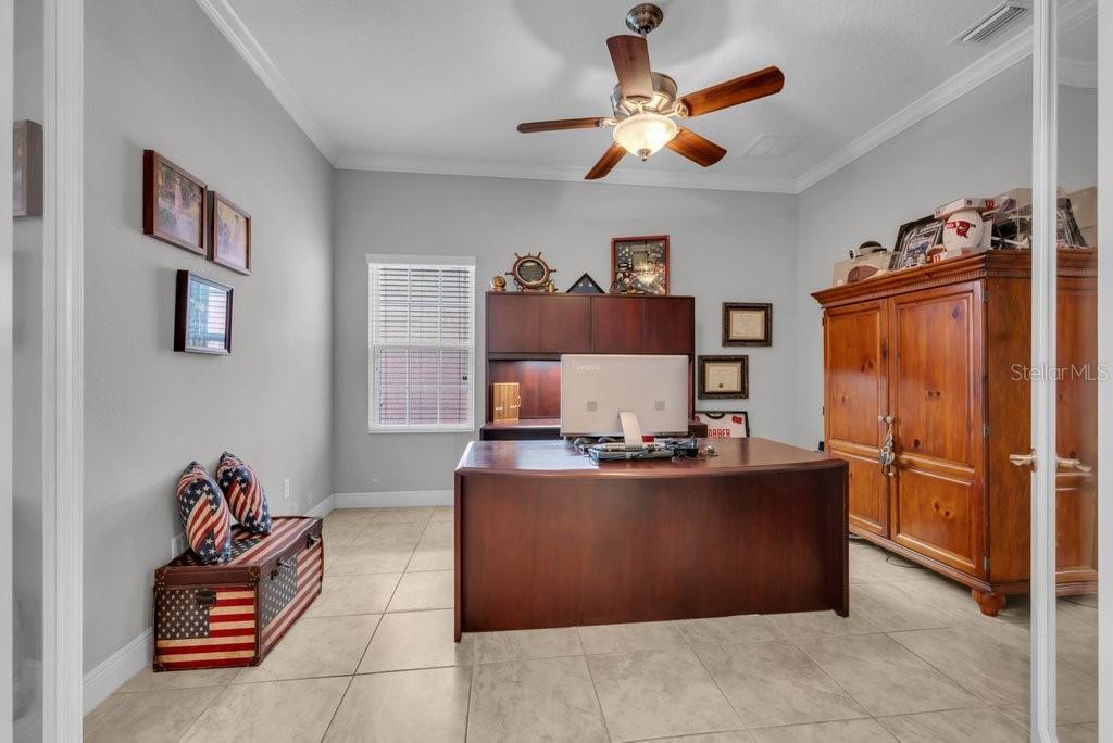 A home office features a dark wood desk, a matching hutch, and tile flooring — 15409 STARLING CROSSING DRIVE, LITHIA, FL