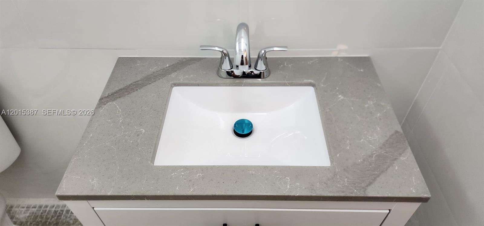 A white bathroom sink is set into a gray marble-patterned countertop with a chrome faucet — 6930 Miami Gardens Dr # 512A, Hialeah FL 33015, HIALEAH, FL