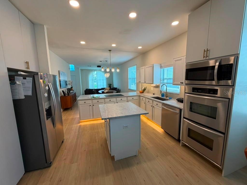 A modern kitchen with white cabinetry, stainless steel appliances, and a central island — 14539 SAINT GEORGES HILL DRIVE, ORLANDO, FL