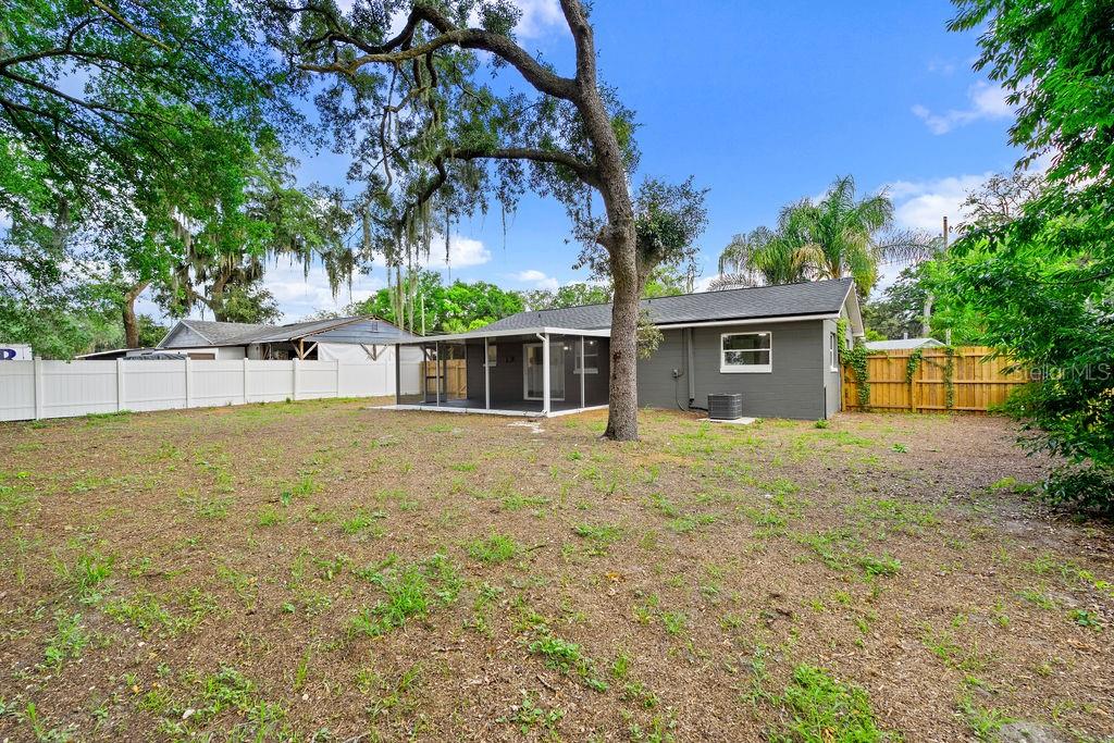 A single-story house with gray siding, a white door, and a concrete driveway — 5399 MUSTANG WAY, ORLANDO, FL