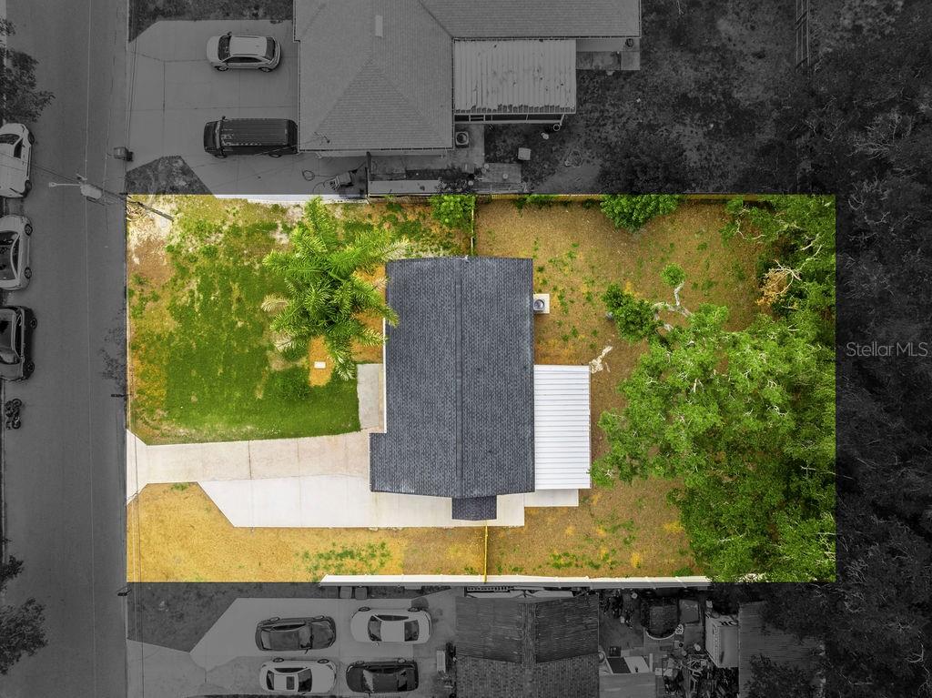 A gray house with a screened-in porch sits in a large, grassy backyard — 5399 MUSTANG WAY, ORLANDO, FL
