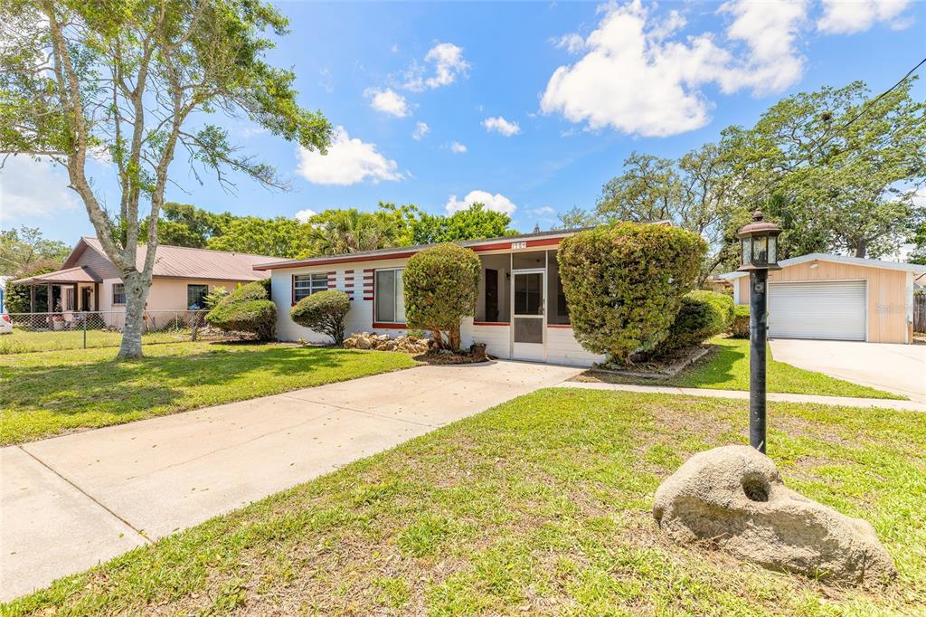 A single-story house with a white exterior, red trim, and a concrete driveway — 1584 VALENCIA AVENUE, DAYTONA BEACH, FL