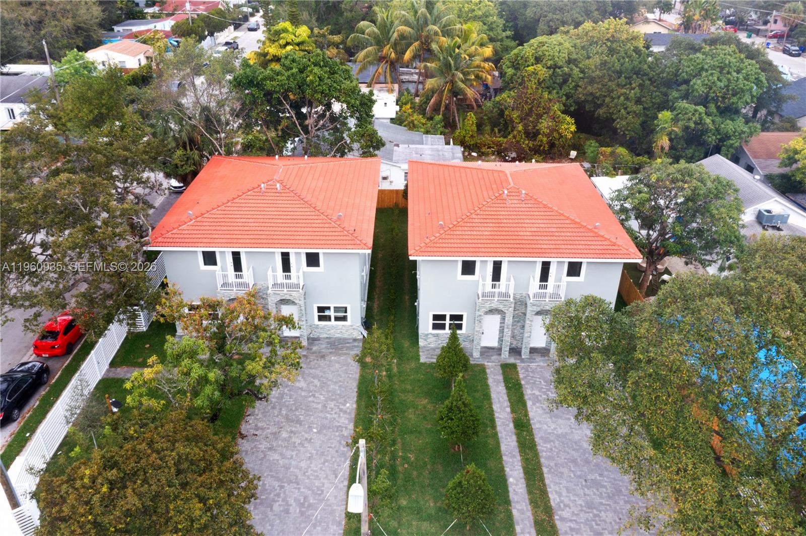 An aerial view shows two identical two-story houses with orange tile roofs and paved driveways — 529 NW 56th St, Miami FL 33127, MIAMI, FL