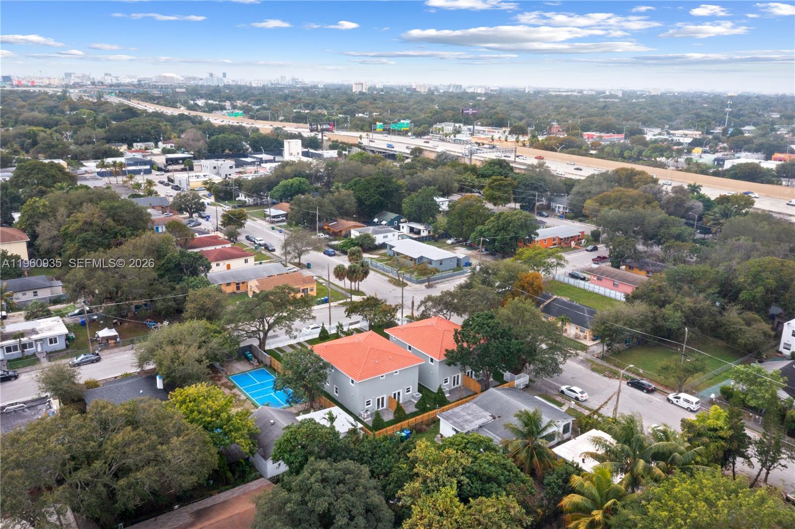An aerial view shows two houses with orange roofs and a blue sports court — 529 NW 56th St, Miami FL 33127, MIAMI, FL