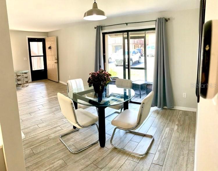 A dining area features a glass-topped table, four white chairs, and sliding glass patio doors — 4022 BEAVER LANE UNIT 800A, PORT CHARLOTTE, FL