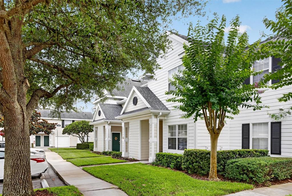 A white two-story townhouse with a front porch and a green door — 1300 EASTERN PECAN PLACE UNIT 102, WINTER GARDEN, FL