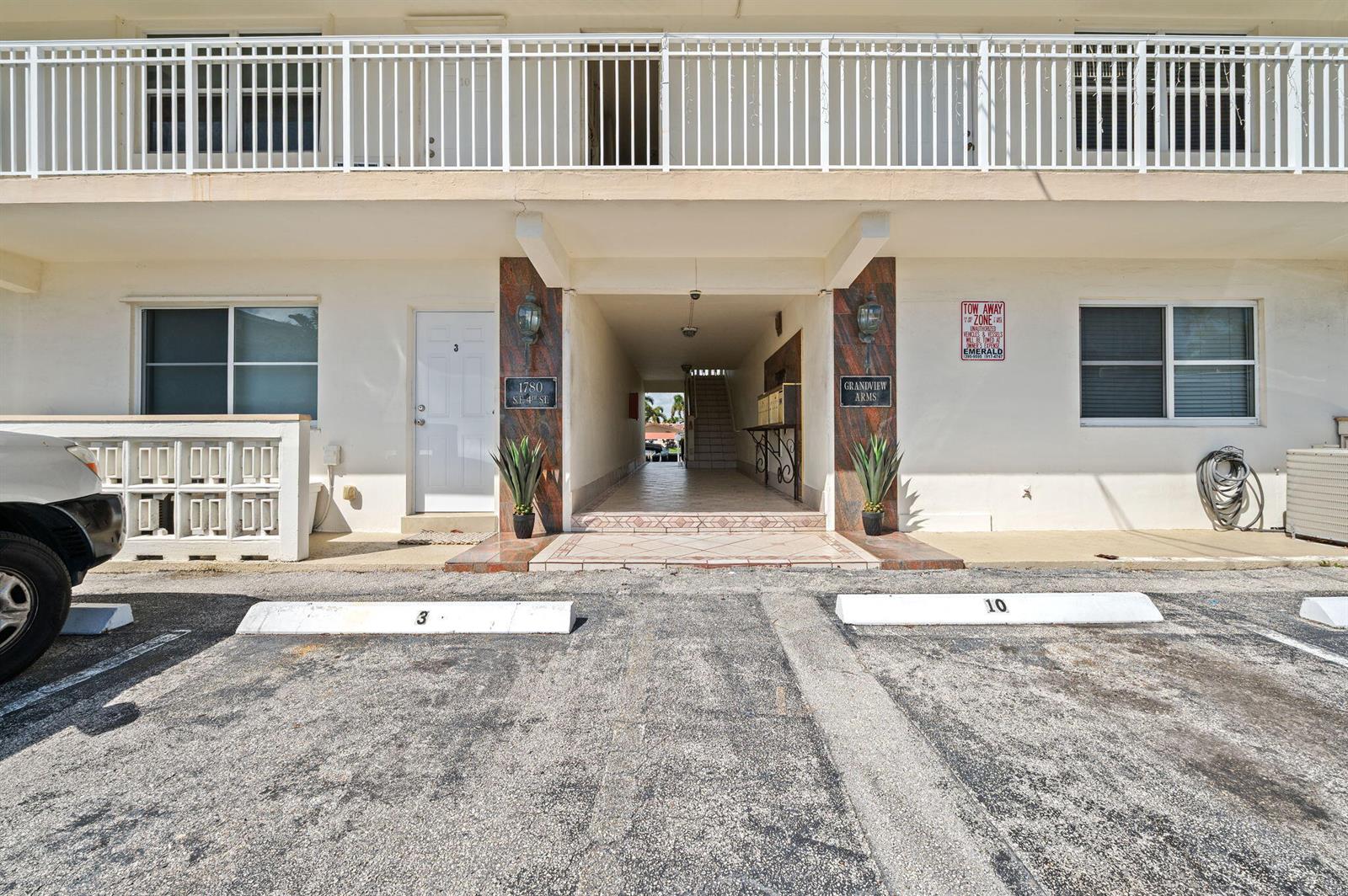 A living room features white tile floors, a wood-paneled accent wall, and a ceiling fan — 1780 SE 4th Street, Pompano Beach FL 33060, POMPANO BEACH, FL