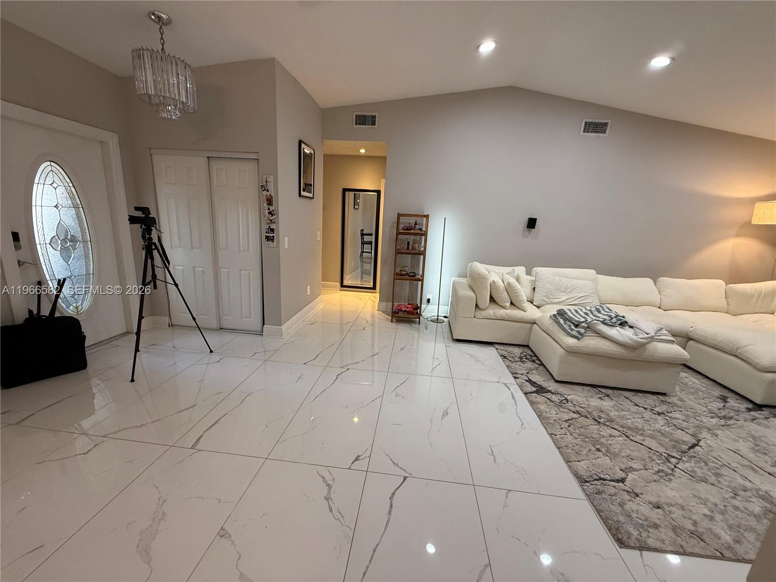 A living room features white marble-look tile flooring, a large sectional sofa, and vaulted ceilings — 20888 Sugarloaf Ln, Boca Raton FL 33428, BOCA RATON, FL