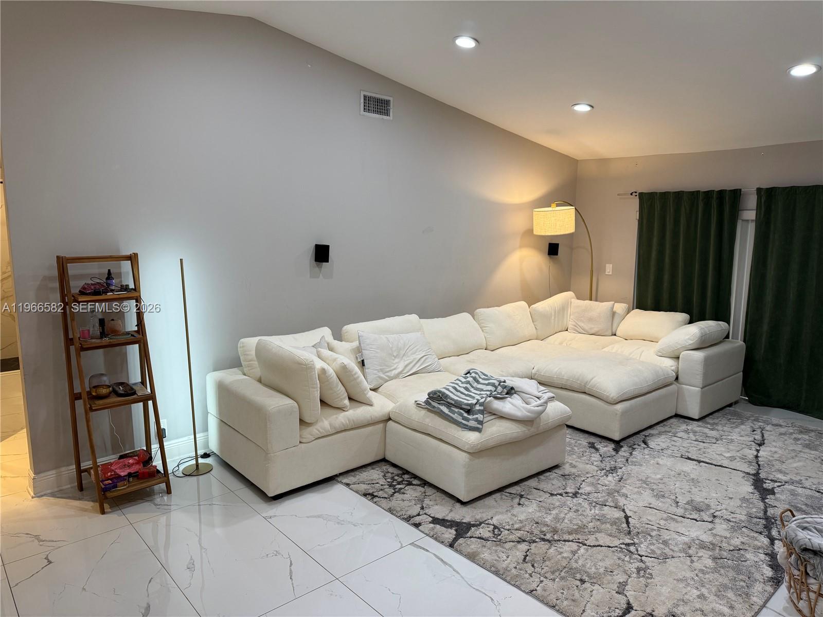 A living room features a large white sectional sofa, a patterned rug, and tile flooring — 20888 Sugarloaf Ln, Boca Raton FL 33428, BOCA RATON, FL