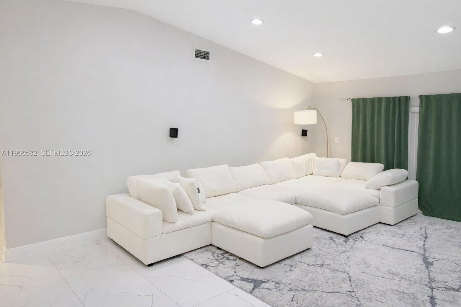 A white sectional sofa sits on a patterned rug in a room with tile floors — 20888 Sugarloaf Ln, Boca Raton FL 33428, BOCA RATON, FL