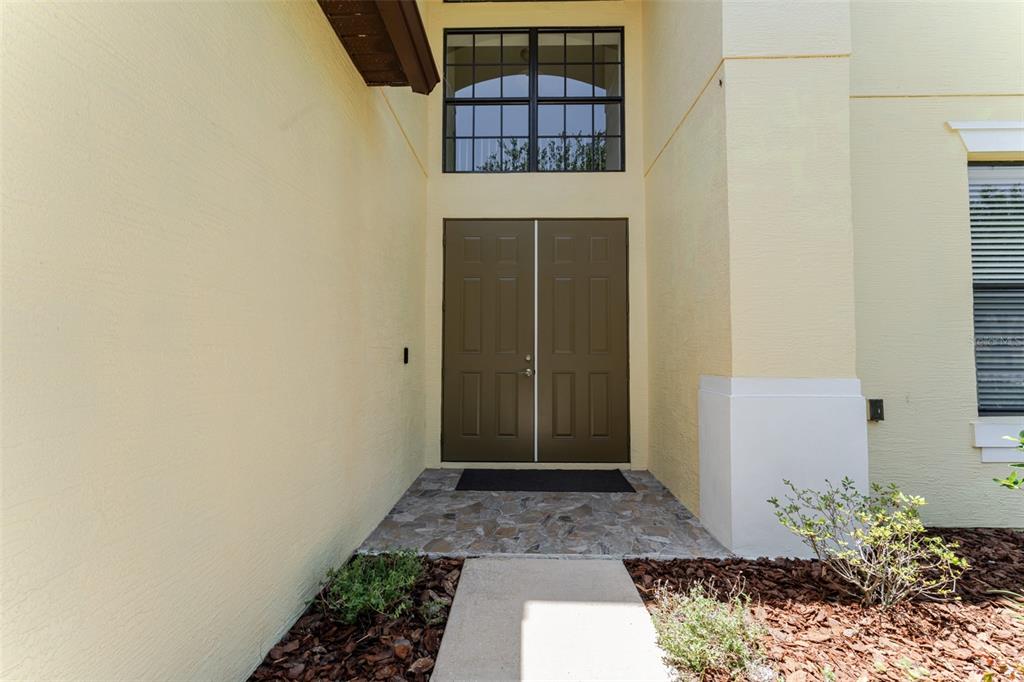 A front entryway features double brown doors, a large transom window, and a stone porch — 1778 WATERSIDE OAKS DRIVE, ORANGE CITY, FL