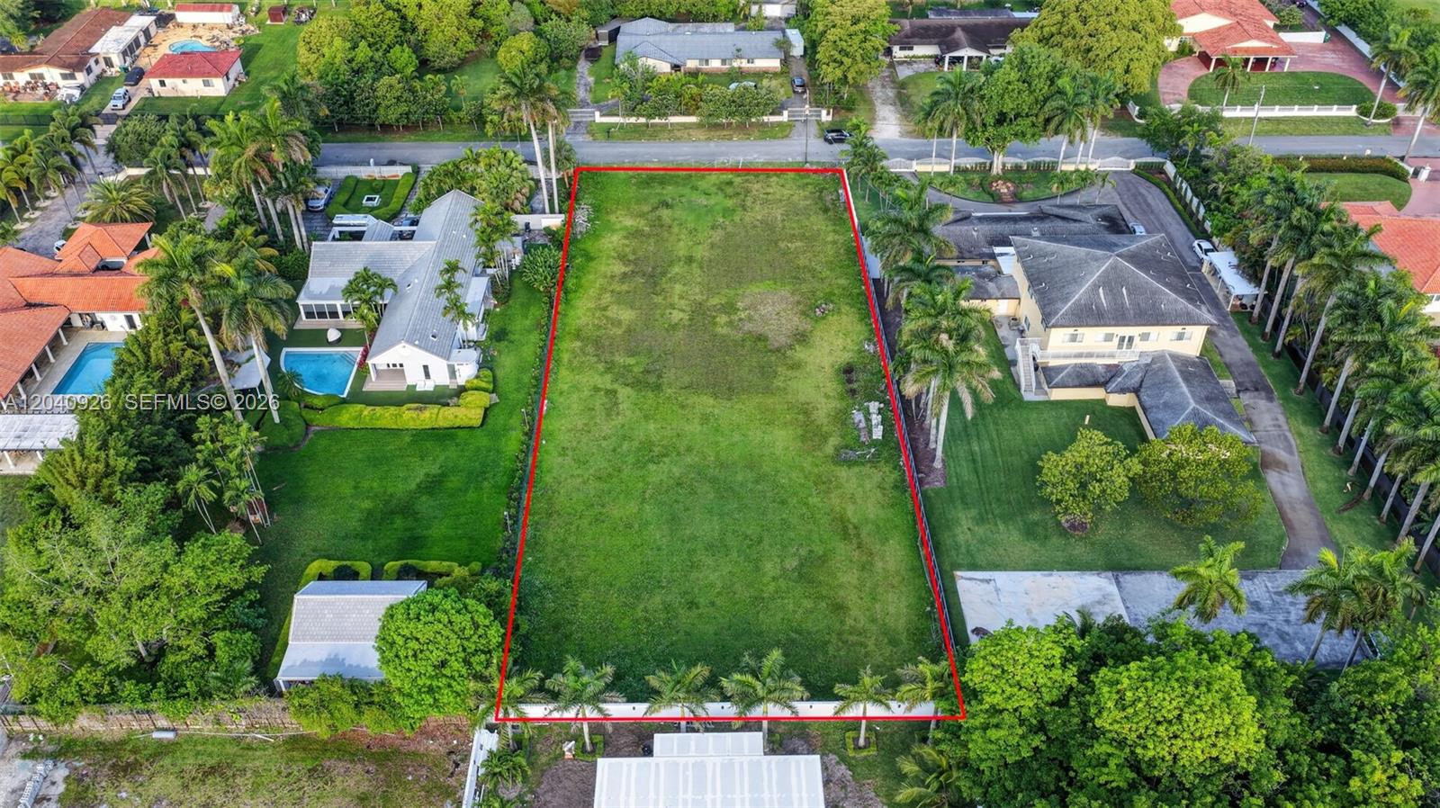An aerial view shows a rectangular vacant lot bordered by residential houses and palm trees — 365 NW 128th AVE, Sweetwater FL 33182, SWEETWATER, FL