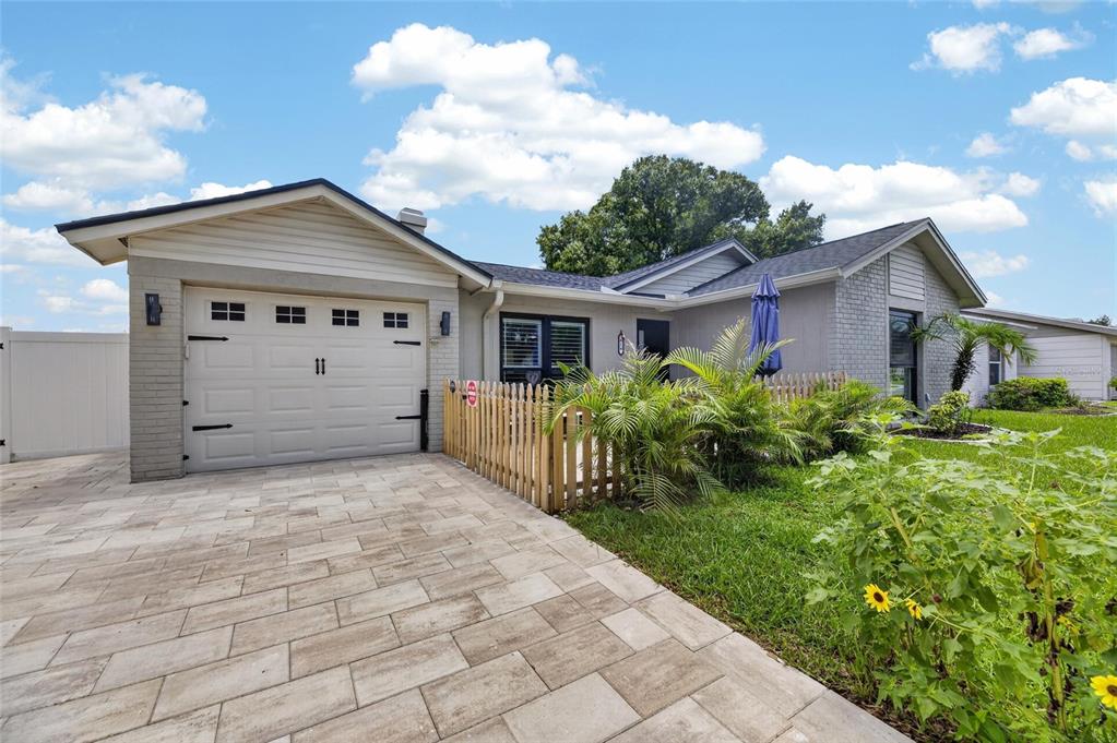A single-story house with a paved driveway, a garage, and a small fenced front yard — 614 STILLVIEW CIRCLE, BRANDON, FL