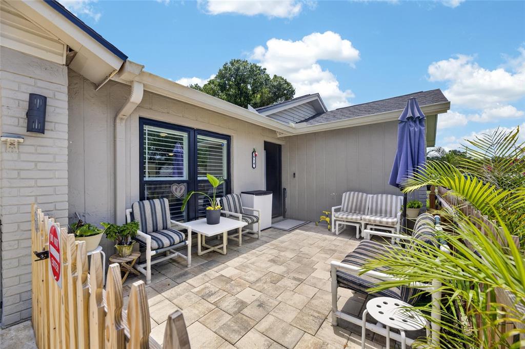 A paved patio features outdoor furniture, a small table, and a wooden fence — 614 STILLVIEW CIRCLE, BRANDON, FL
