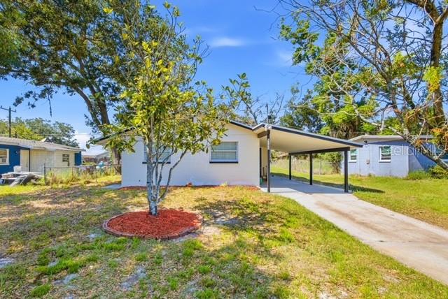 A white single-story house features a carport and a small tree in the front yard — 1105 LINCOLN TERRACE, WINTER GARDEN, FL
