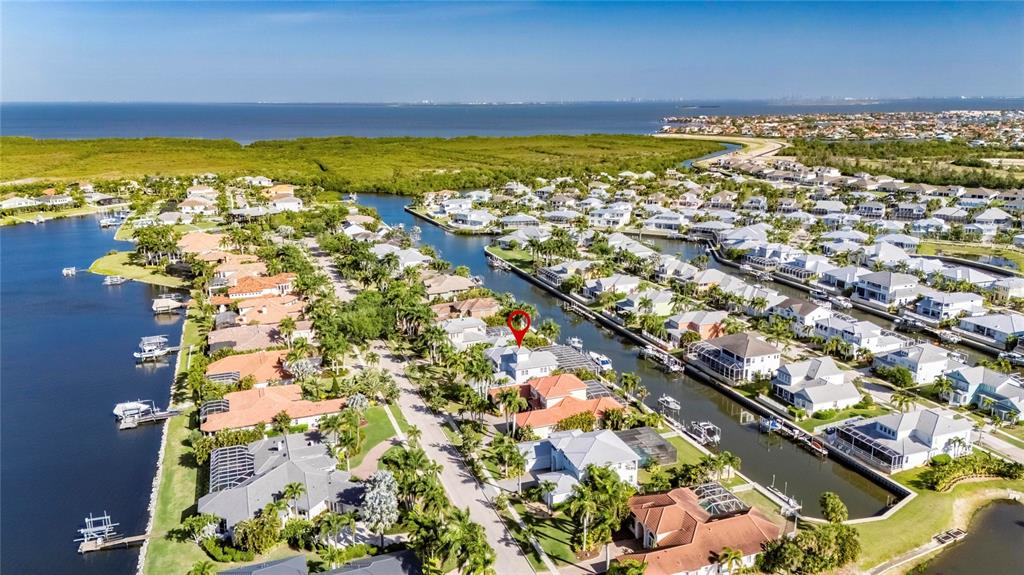 An aerial view shows a residential neighborhood with houses along canals leading to the ocean — 613 BALIBAY ROAD, APOLLO BEACH, FL