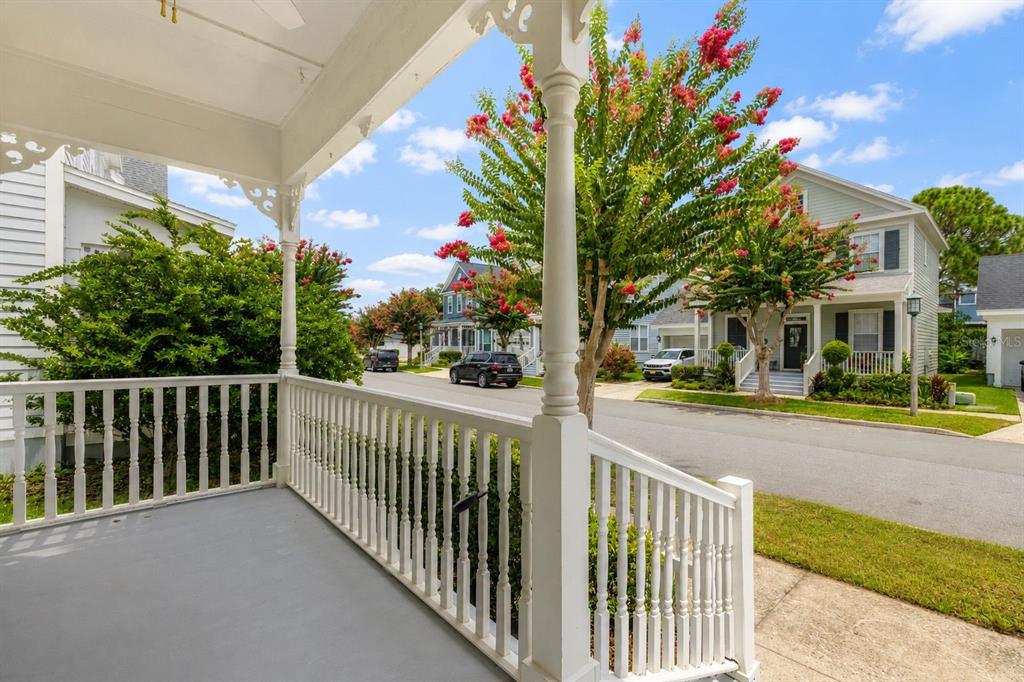 A view from a white-railed porch looking out onto a suburban street with houses — 167 LONGVIEW AVENUE, CELEBRATION, FL
