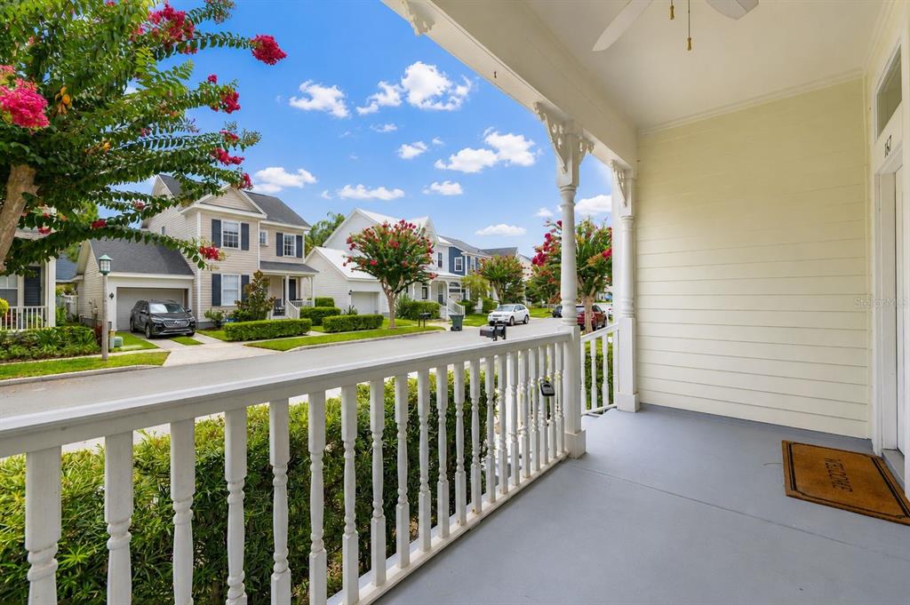 A covered front porch with a white railing overlooks a suburban street with houses — 167 LONGVIEW AVENUE, CELEBRATION, FL