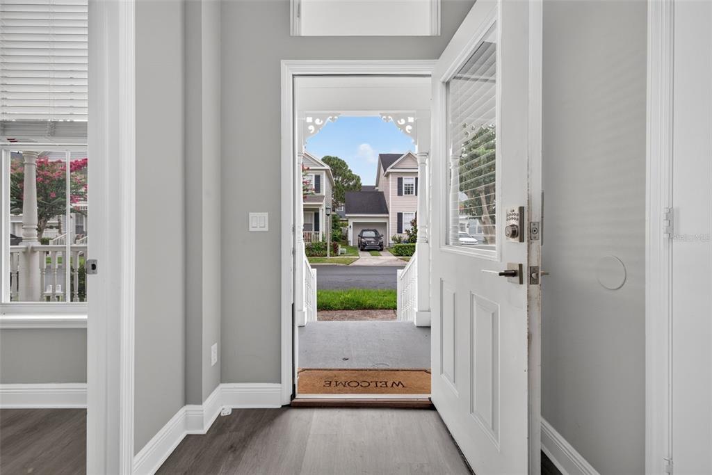 An open front door reveals a porch, a street, and neighboring houses from an entryway — 167 LONGVIEW AVENUE, CELEBRATION, FL