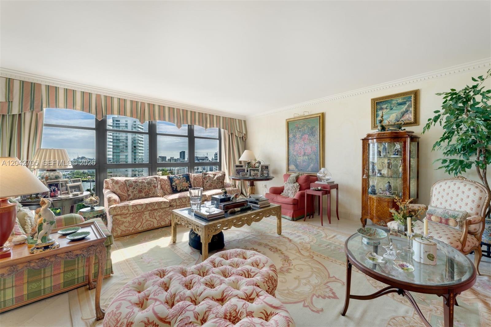 A traditional living room features floral upholstered furniture, a glass coffee table, and floor-to-ceiling windows — 9 Island Ave # 1514, Miami Beach FL 33139, MIAMI BEACH, FL