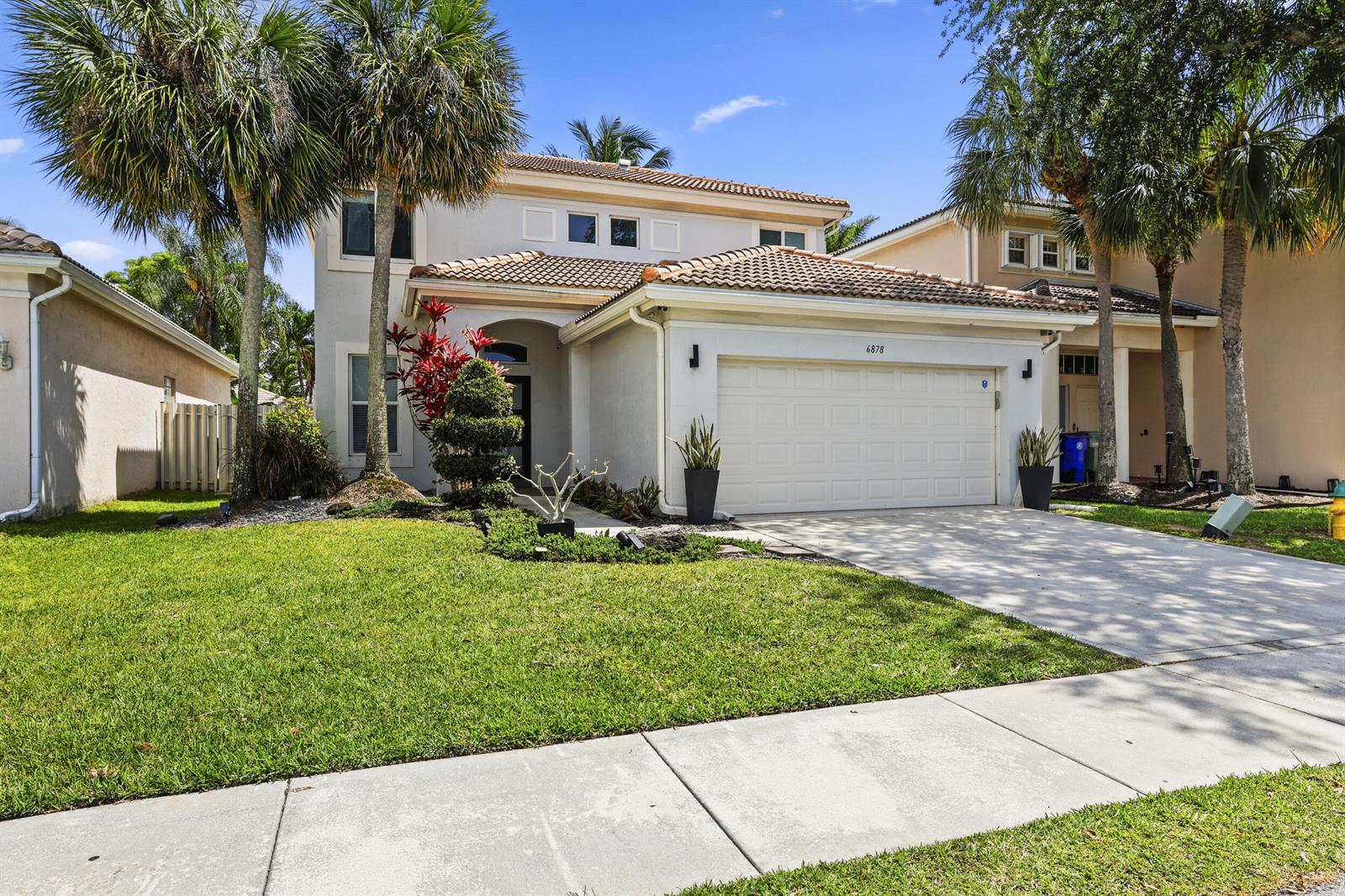 A two-story suburban house with a tile roof, a garage, and palm trees in front — 6878 NW 33rd Street, Margate FL 33063, MARGATE, FL