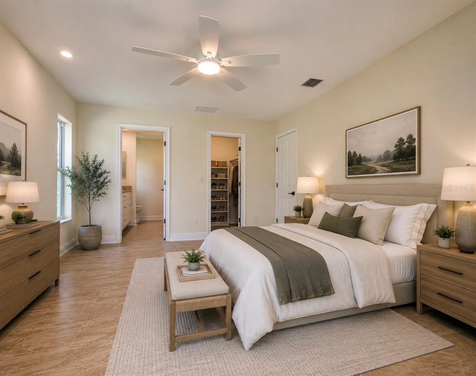 A bedroom features a bed, a ceiling fan, a walk-in closet, and an attached bathroom — 121 MARINER LANE, ROTONDA WEST, FL