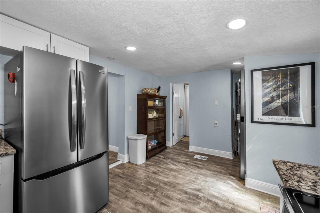A kitchen features stainless steel appliances, light blue walls, and wood-look flooring — 504 70TH AVENUE, ST PETE BEACH, FL