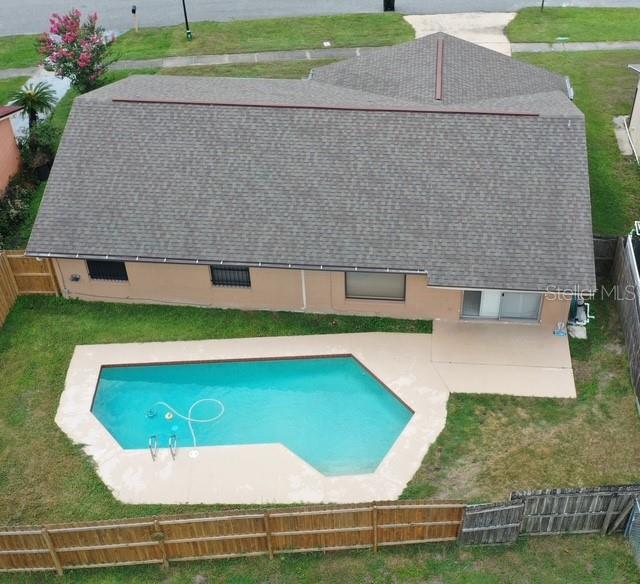 An aerial view shows a house with a shingled roof, backyard pool, and wooden fence — 2311 TOWERBRIDGE STREET, ORLANDO, FL