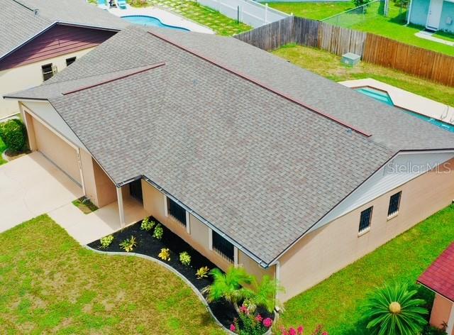 An aerial view shows a tan house with a gray shingled roof and a pool — 2311 TOWERBRIDGE STREET, ORLANDO, FL
