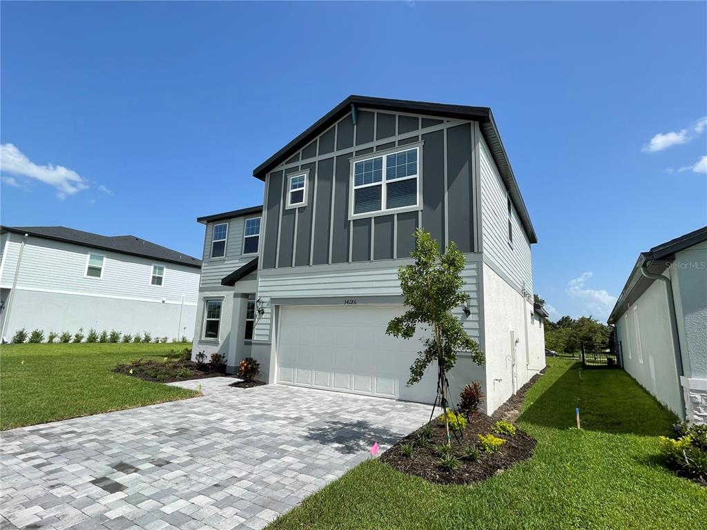 A two-story house with a gray and white exterior, a two-car garage, and a paved driveway — 34286 EVERGREEN HILL COURT, WESLEY CHAPEL, FL