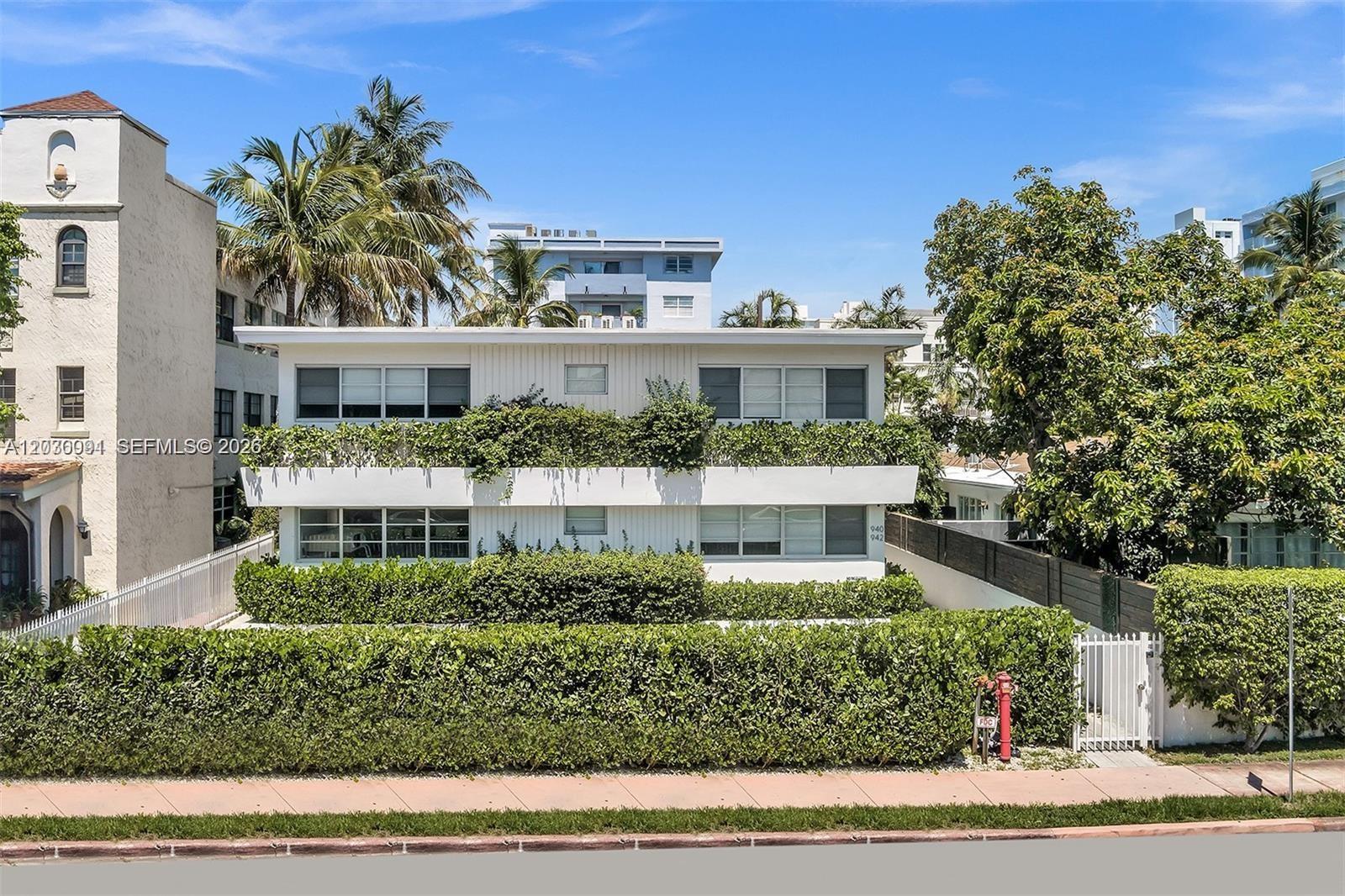 A two-story white apartment building is surrounded by lush green hedges and palm trees — 940 Michigan Ave # 10, Miami Beach FL 33139, MIAMI BEACH, FL