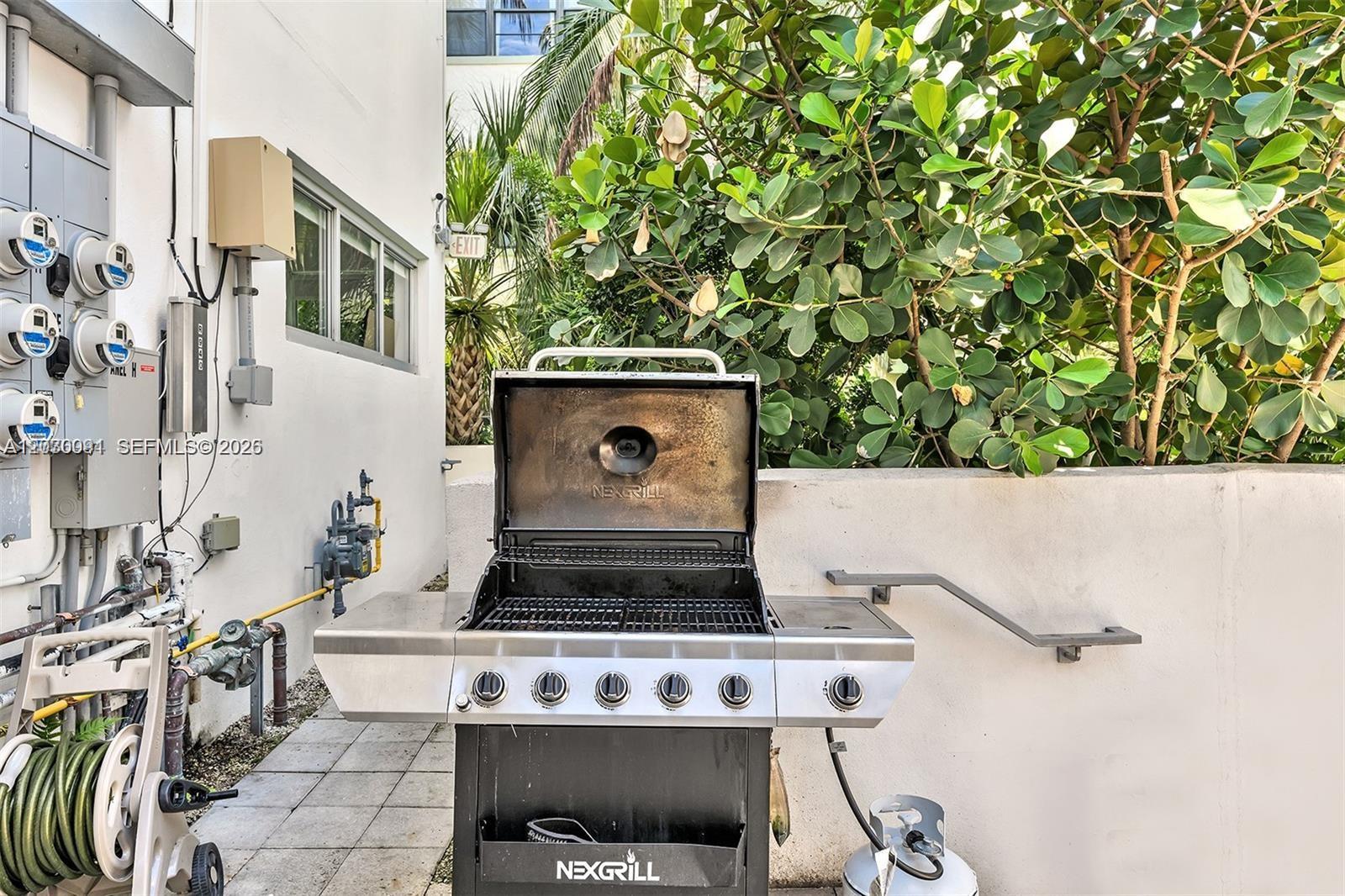A stainless steel Nexgrill stands on a paved patio next to a white wall — 940 Michigan Ave # 10, Miami Beach FL 33139, MIAMI BEACH, FL