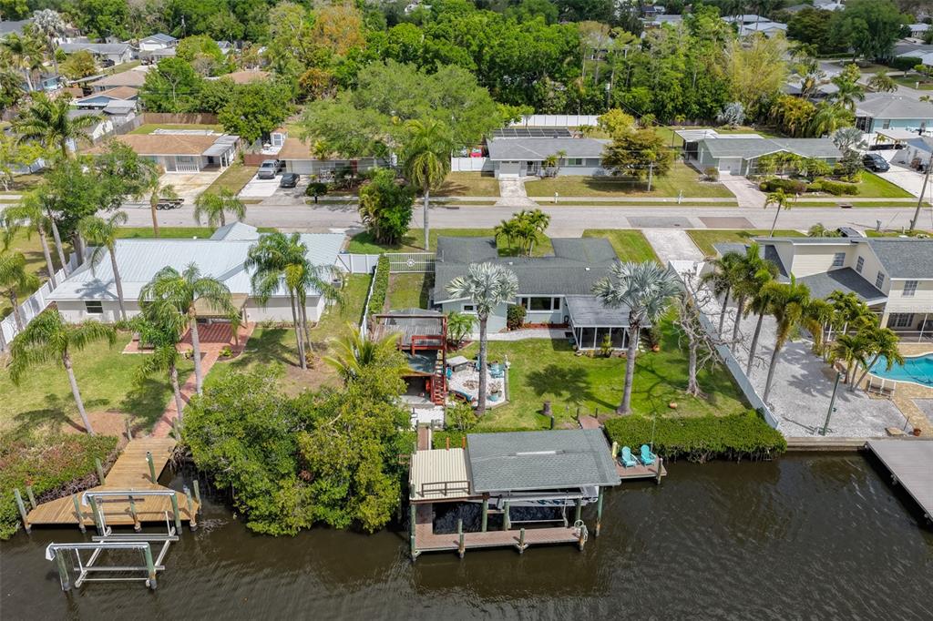 An aerial view shows two waterfront houses with private docks and palm trees — 6907 9TH AVENUE NW, BRADENTON, FL